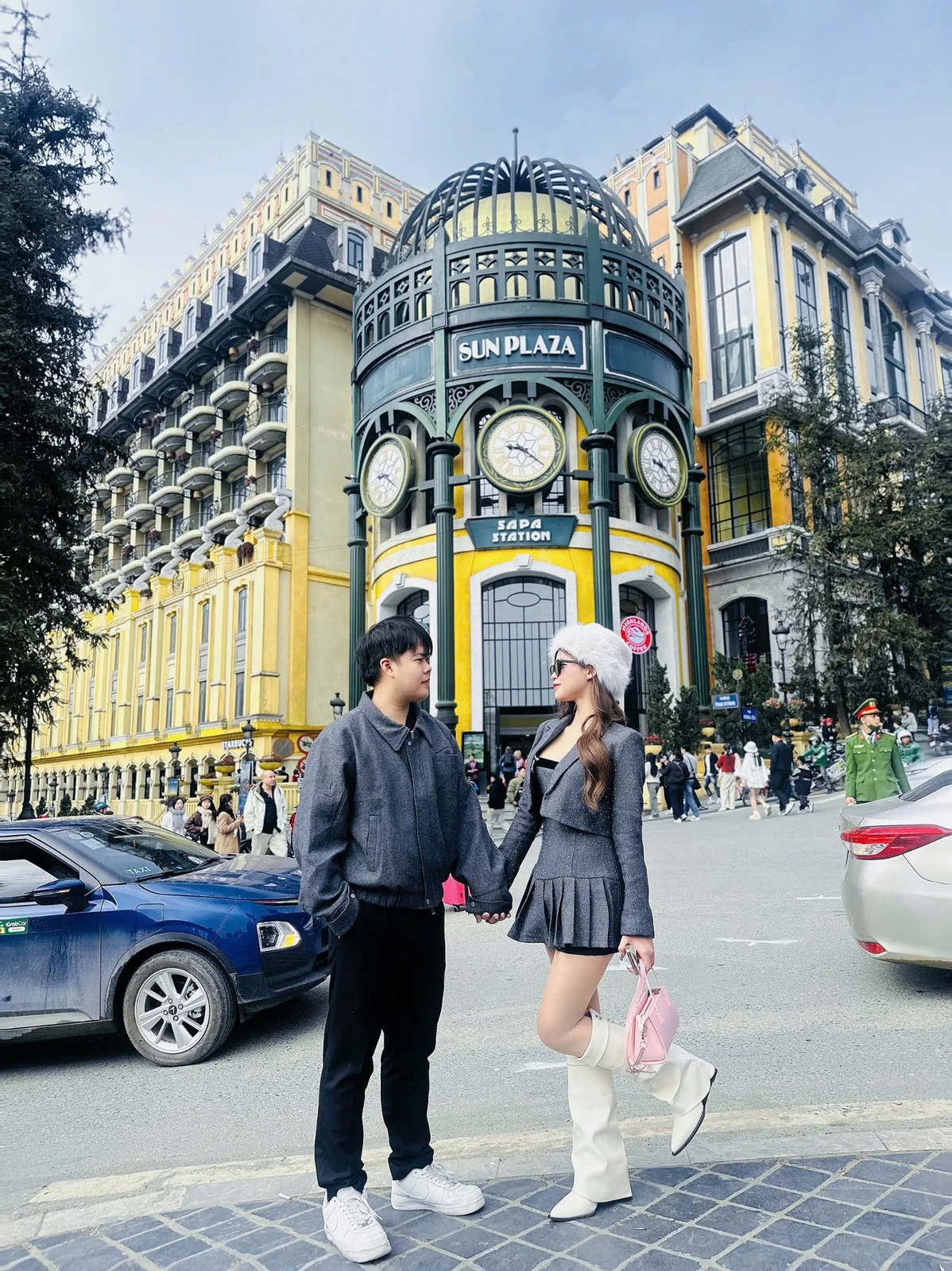 Hai người nắm tay trước tòa nhà Sun Plaza tại Sa Pa